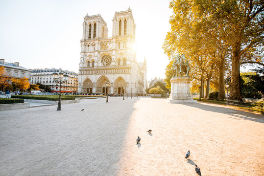 View on the famous Notre-Dame cathedral and empty square during the morning light in Paris, France