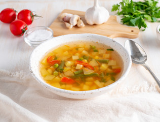 Healthy spring vegetable dietary vegetarian soup, white wooden background, side view, close up