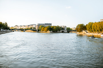 Fototapeta premium Landscape view on the riverside from the boat sailing on Seine river during the sunset in Paris