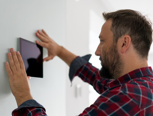 Fototapeta premium Man using smart home device