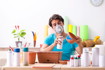 Young man decorating pottery in class