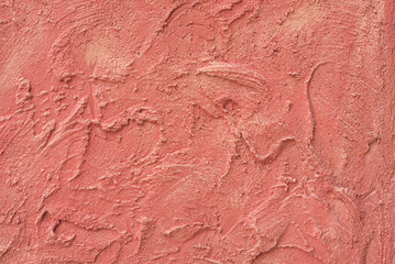 Relief stucco on the wall. Red color. Close up