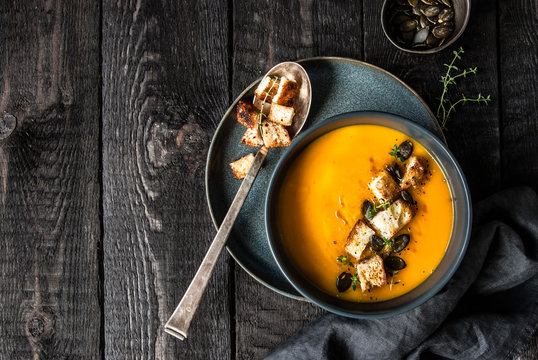 Zupa krem z dyni. Podana z grzankami, pestkami dyni i oliwą.