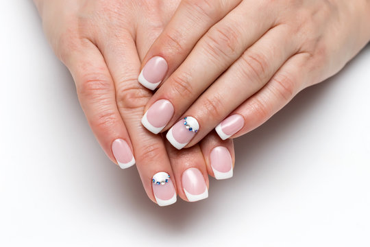 Wedding French manicure with crystals on short square nails on a white background close-up