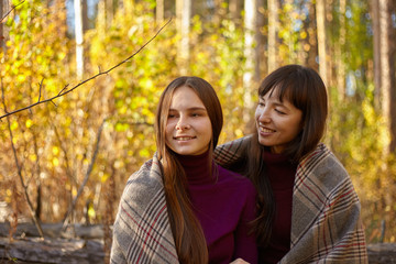 Fototapeta premium Cute portrait of mother and daughter in the autumn forest.