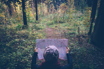 Young traveler woman with map,at autumn green forest in sunny day. Relaxing outdoor, hiking...