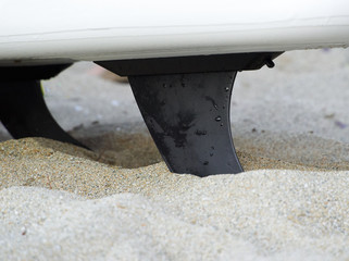 surfboard fins on sand