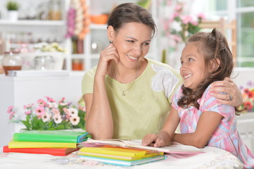 Fototapeta premium little girl with her mother doing homework