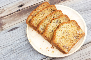 Homemade banana cake on wood plate. Over wooden table.Top view with copy space.