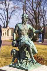statue of a seated man in the park Mezhyhirya on the background of yellow foliage and trees. Ukraine, Kiev. Mezhyhirye. February 24, 2014.