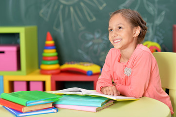 Portrait of a cute schoolgirl doing homework