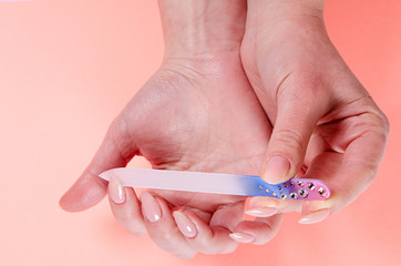 Manicure nail woman glass nail file on pink background