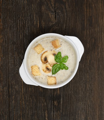 champignon soup with crackers on wooden background