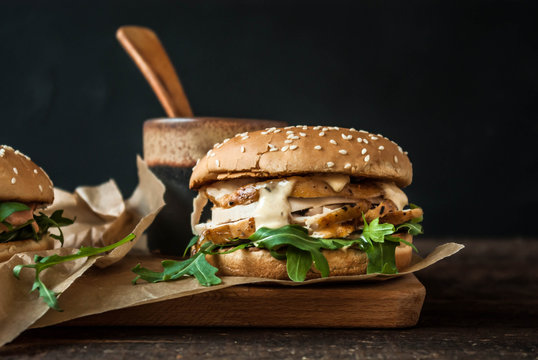 Burgery z mięsem z kurczaka, rukola i musztardowym sosem. Podane na desce.