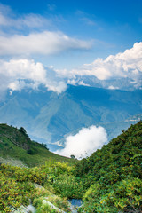 mountains valley in summer afternoon with gentle clouds over peaks