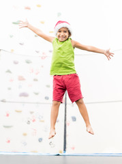 Little boy with Santa hat jumping on trampoline