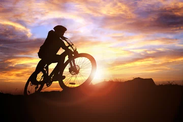 Peel and stick wall murals Bicycles Mountain biker silhouette in action against the sunset concept for sport and exercise