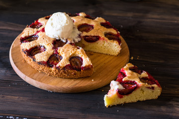 Homemade plum pie on the old wooden background. Still life of food. plum tart. Autumn harvest. Old fashion cuisine. Portion. Plum bakery. Rustic open pie. Winter pie. New York pie. Ice cream.