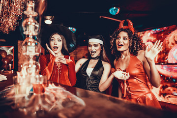 Women in Costumes Looking at Flaming Cocktail