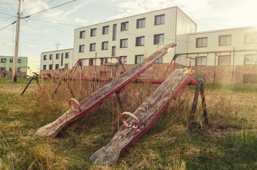 Old swings in a park amongst long abandoned apartment buildings