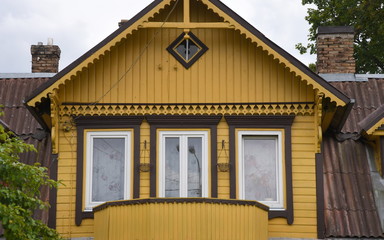 Gelber Giebel mit Balkon an einem historischen Holzhaus im Vilniuser Stadtteil Šnipiškės