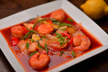 shrimps in tomato sauce on a white plate
