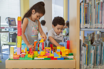 Sister and brother have the building block table to themselves.