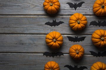 Halloween pumpkins and black vampire bats on a wooden background