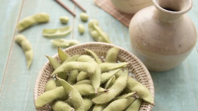 Green Japanese Soybean in wooden bowl on table wood, Fresh steamed edamame sprinkled with sea salt
