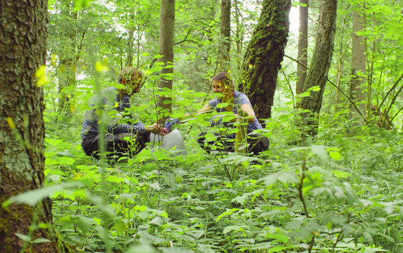 Man and woman scientists environmentalist in the forest. They taking samples of a sod