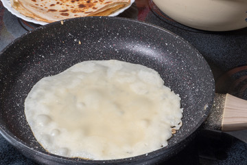 Raw fucking on a black frying pan in the frying process. Photo format horizontal
