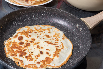 Fried pancake in a pan during frying. Photo format horizontal