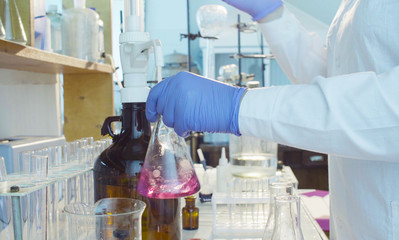 Chemical analysis laboratory. Close up hands of a scientist titrating solution.