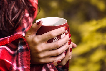 cup of herbal tea in woman hands. Autumn fall close up