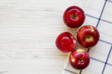 Fresh raw red apples on white wooden background, overhead view. Flat lay, from above, top view. Copy space.