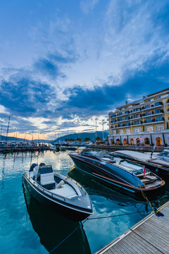 Luxurious motor boats at Porto Montenegro marina with spectacular sunset at background