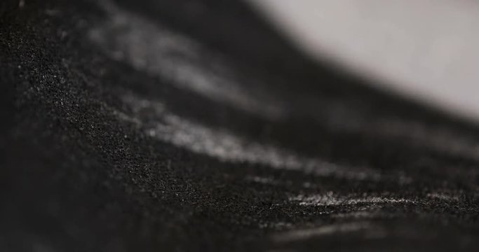 Soft black and white background texture shot moving from defocused to raster printed abstract textile shapes to defocused again.