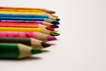 set of colored pencils lying on the notebook. White background. Isolate. Christmas colors