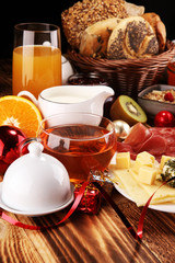 breakfast on table with bread buns, croissants, coffe and juice on christmas day. xmas holiday morning.