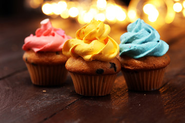 Tasty cupcakes on christmas winter background. Birthday cupcake in rainbow colors.