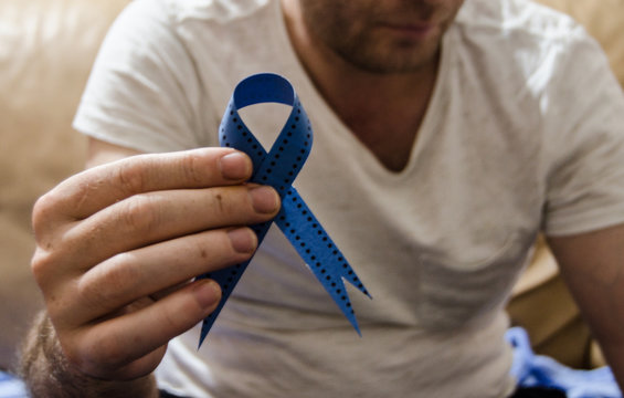 Man holding a blue ribbon, blue november concept