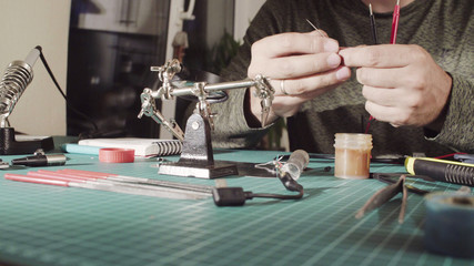 Close up. Repairing of wire for electronic devices.