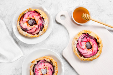 Small apple pies on the textured white table