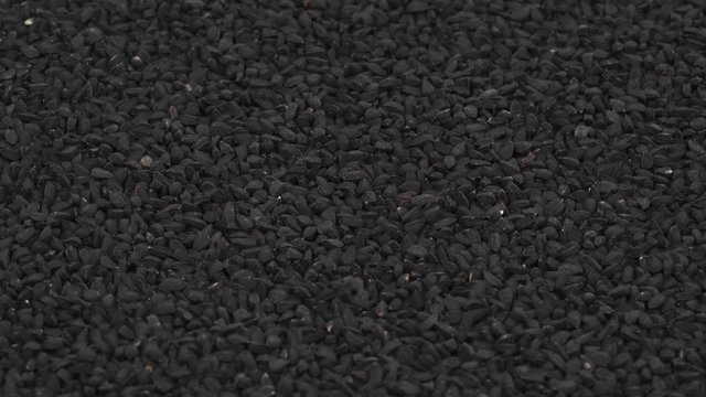 Macro shooting of black cumin heap slowly rotating. Close up.