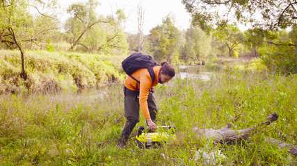Woman scientist ecologist putting the tool box on the ground