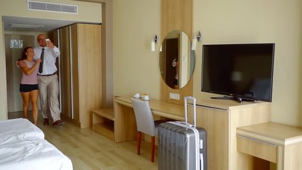 Two lovers starting kissing in hotel room and going in bed.