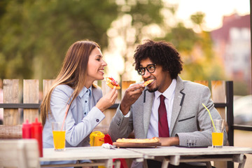 Happy young business team eating pizza in outdoor cafe.Business,food and people concept.