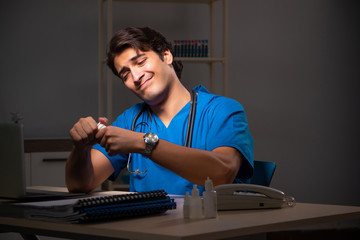 Young handsome doctor working night shift in hospital   