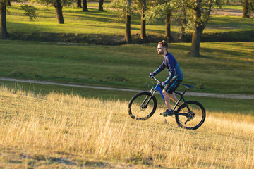 A cyclist rides the hills, Beautiful portrait of a guy on a blue bicycle