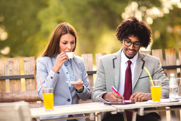 Business people looking at digital tablet and discuss about the future project plan in outdoor cafe.